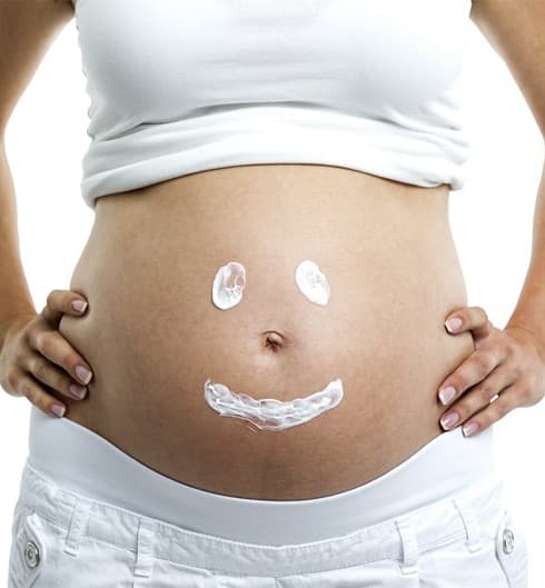 Schwangere Frau hält ihren Bauch